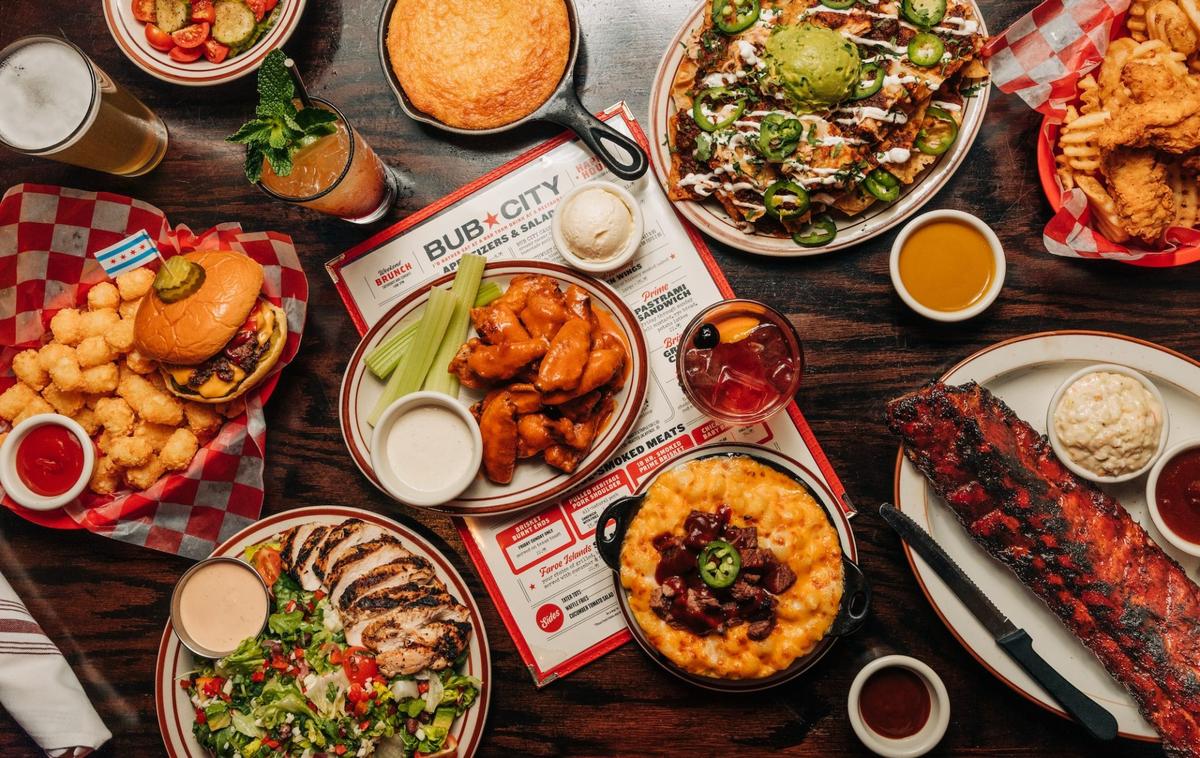 a spread of bub city menu items, wings, burgers, southwest salad, ribs, mac and cheese, nachos