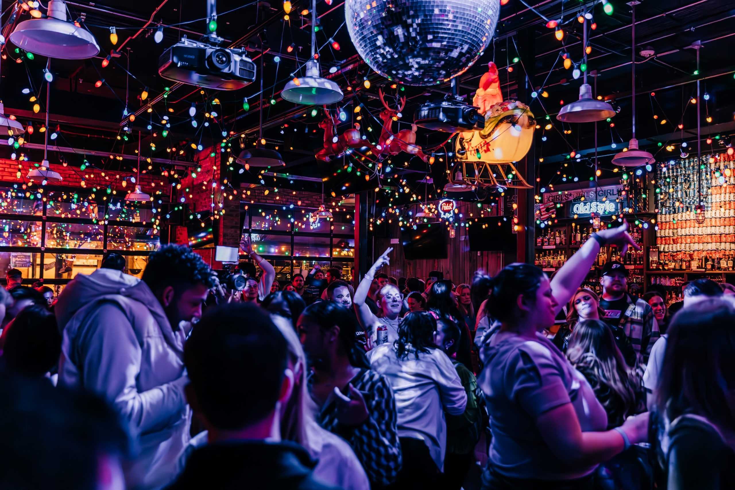 People on a dance floor with a disco ball.