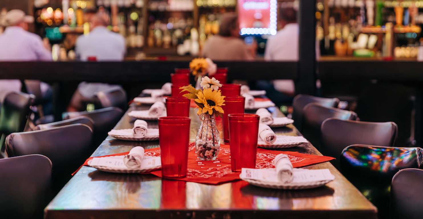 a table set with red cups and plates