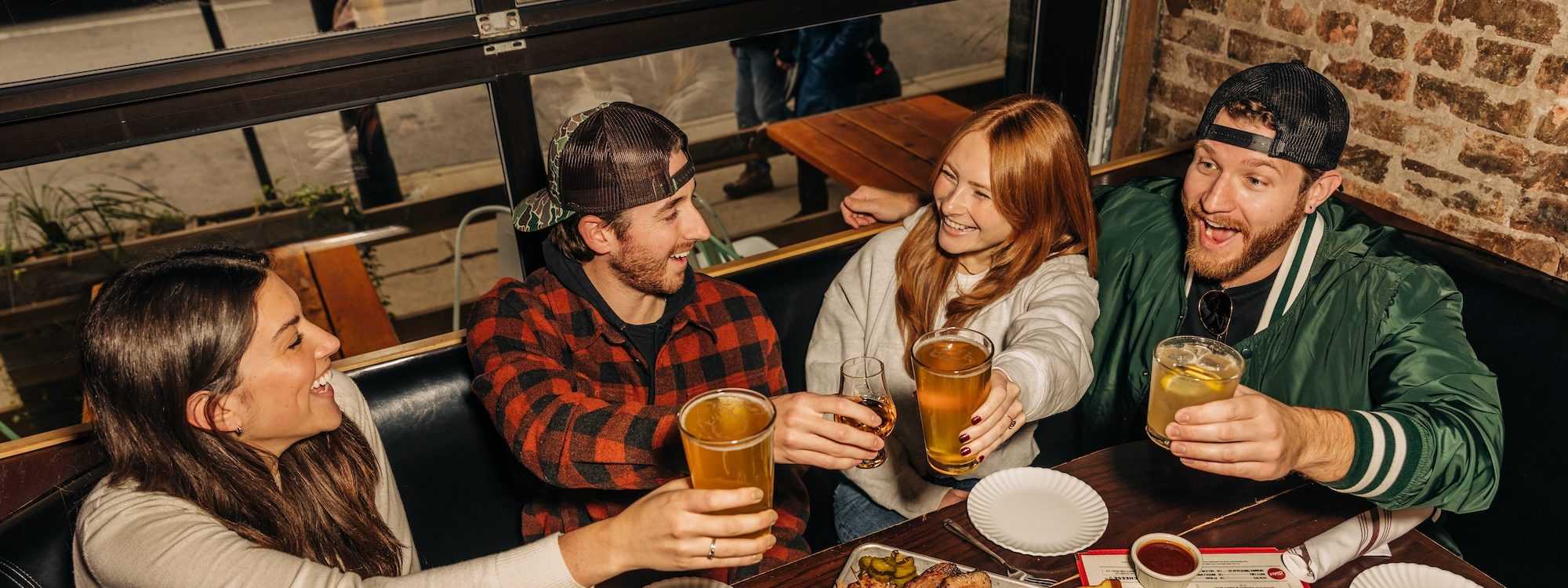 a group of four people cheersing