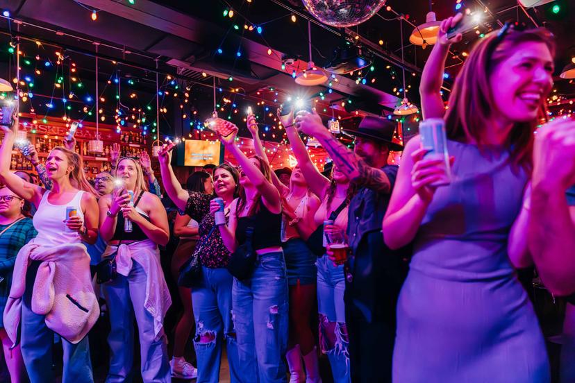 a crowd of people have their phones in their hands with the flashlight on and sing