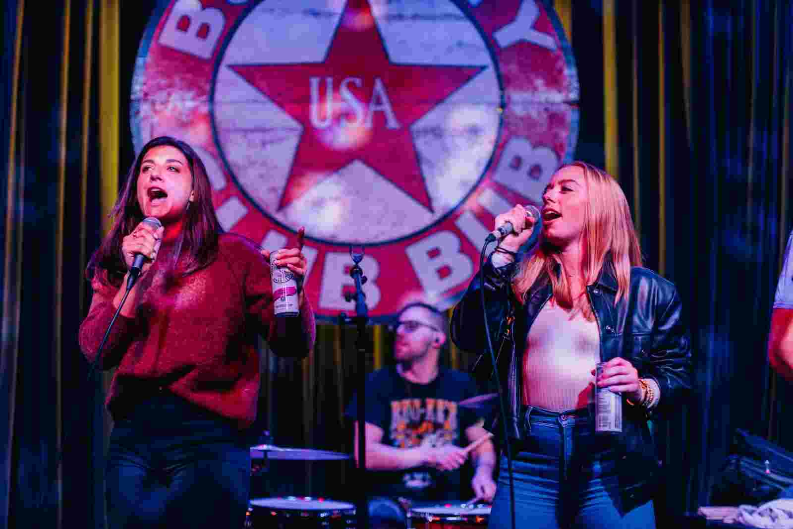 Two girls singing songs on a stage